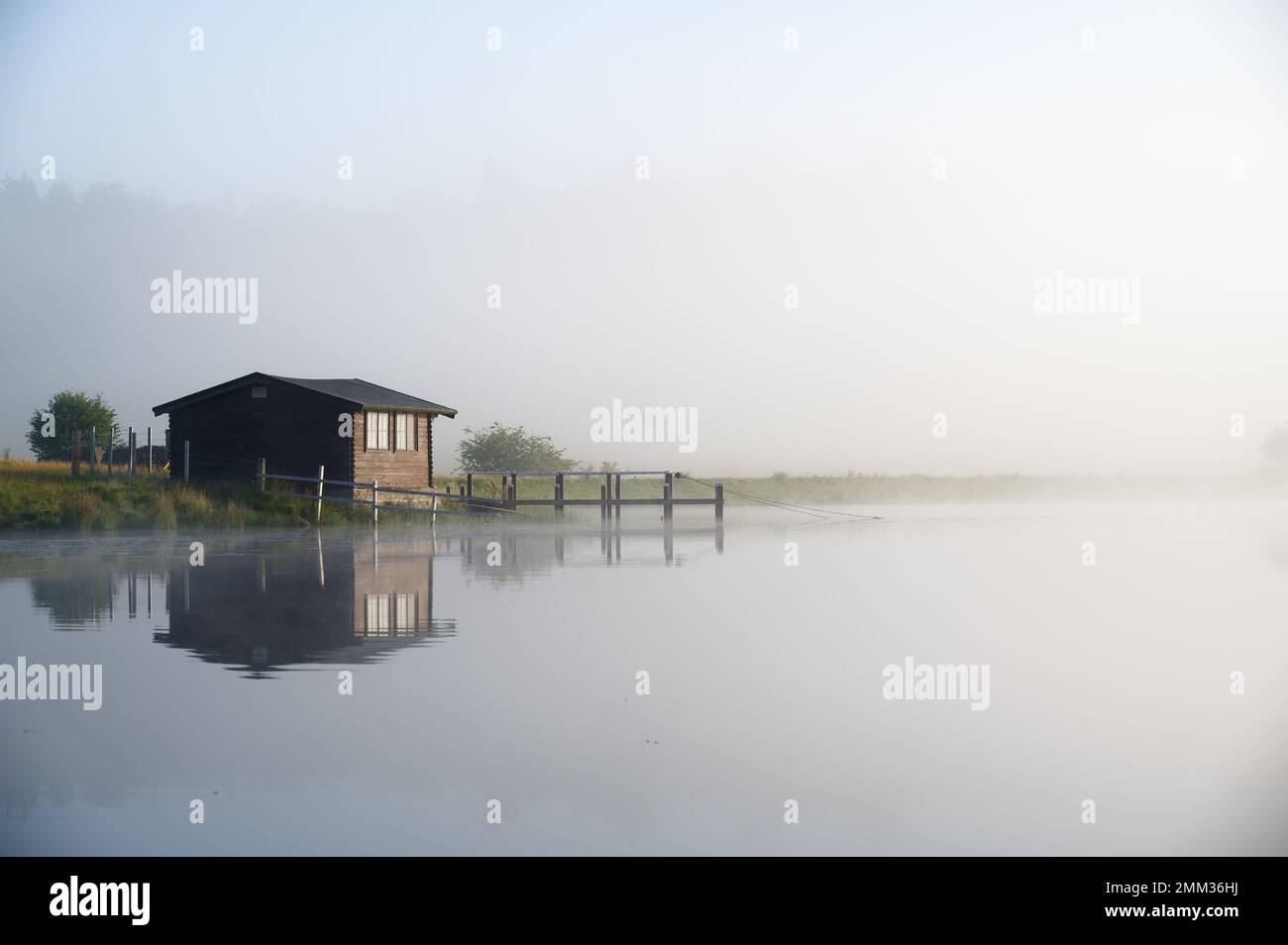 Fishing boats in lake and early morning mist at sunrise Stock Photo - Alamy