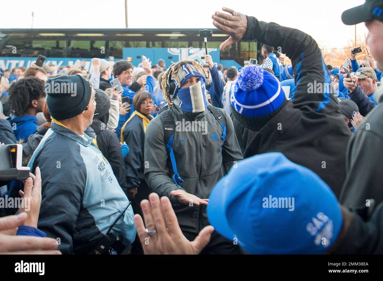 Kentucky running back Benny Snell Jr. , his face wrapped in a scarf, greets  fans before the