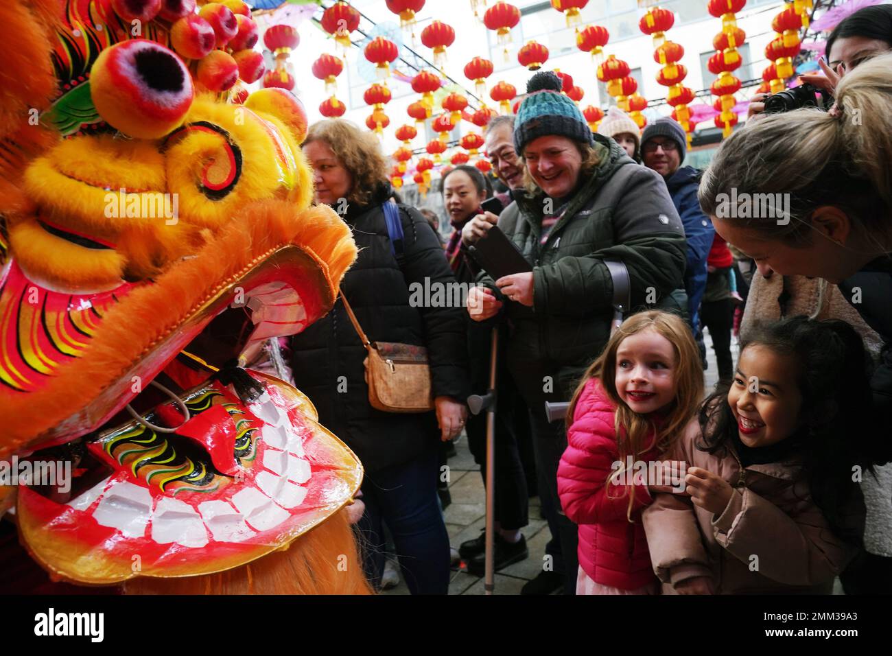 ***PARENTAL PERMISSION GIVEN**** Maria Larkin (centre), 6, and Linna Basso (right), 5, react as they meet members of the Flower City Dragon and Lion Dance Association following a Cantonese Lion Dancing performance in Dublin's city centre as part of Dublin Lunar New Year’s flagship event of the Chinese New Year festival. Picture date: Sunday January 29, 2023. Stock Photo