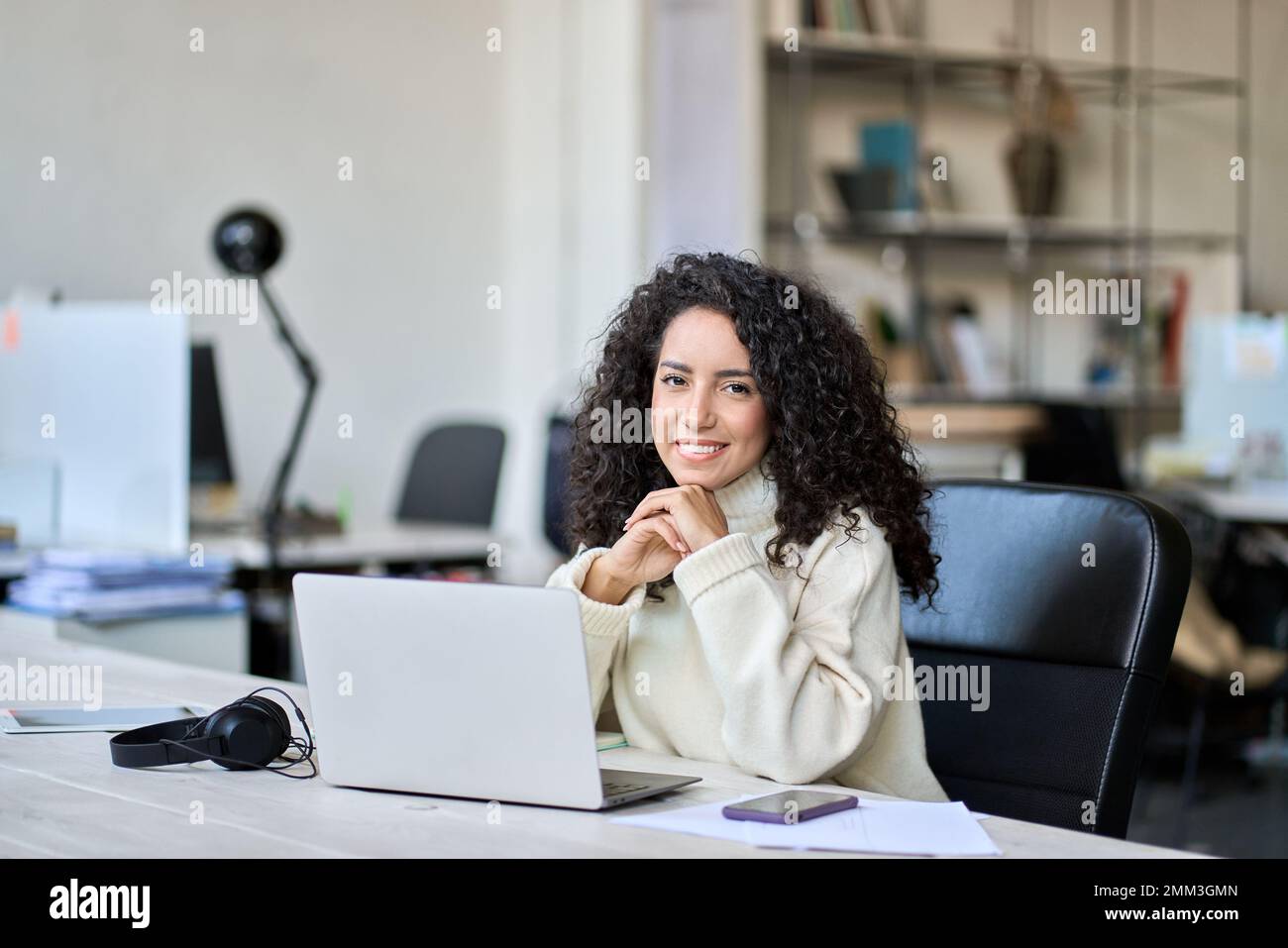 Young happy latin business woman sitting at office desk with laptop ...