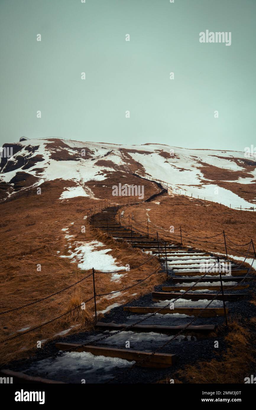 icy stairways up to snowy mountain with foggy sky in island Stock Photo