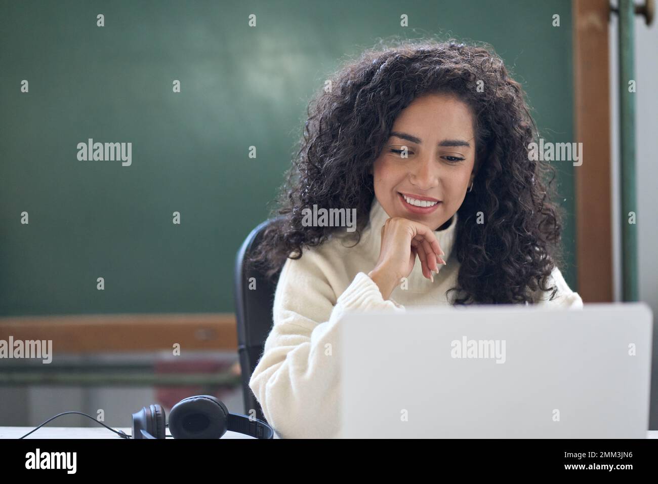 Young woman school teacher, online tutor sitting at desk teaching remote class. Stock Photo