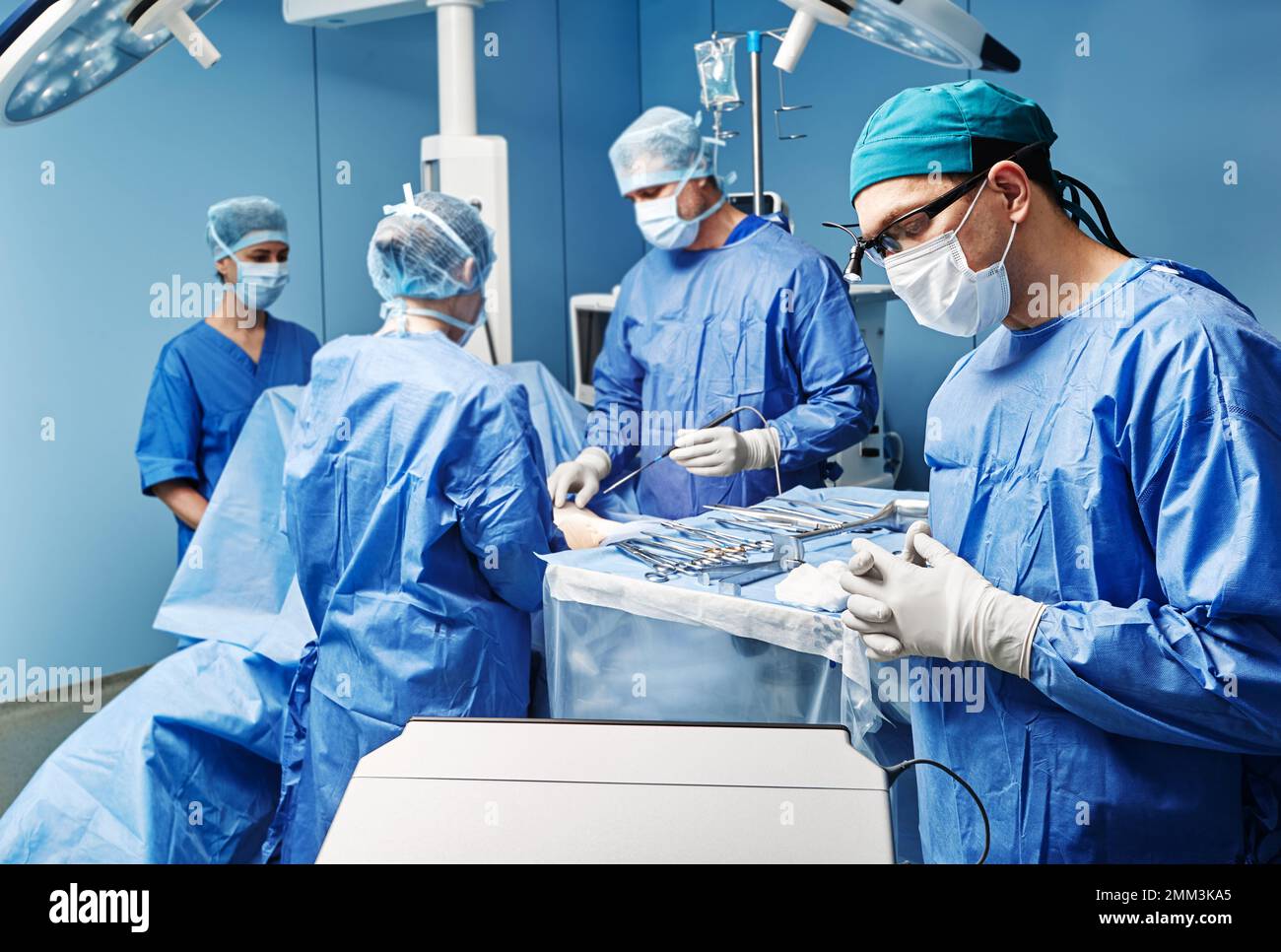 Surgical medical team performing surgical operation in modern operating room Stock Photo
