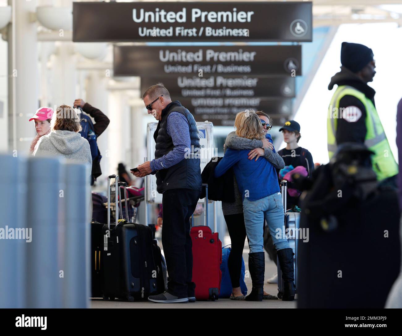 Women exchange farewells at the curbside baggage checkpoint outside the