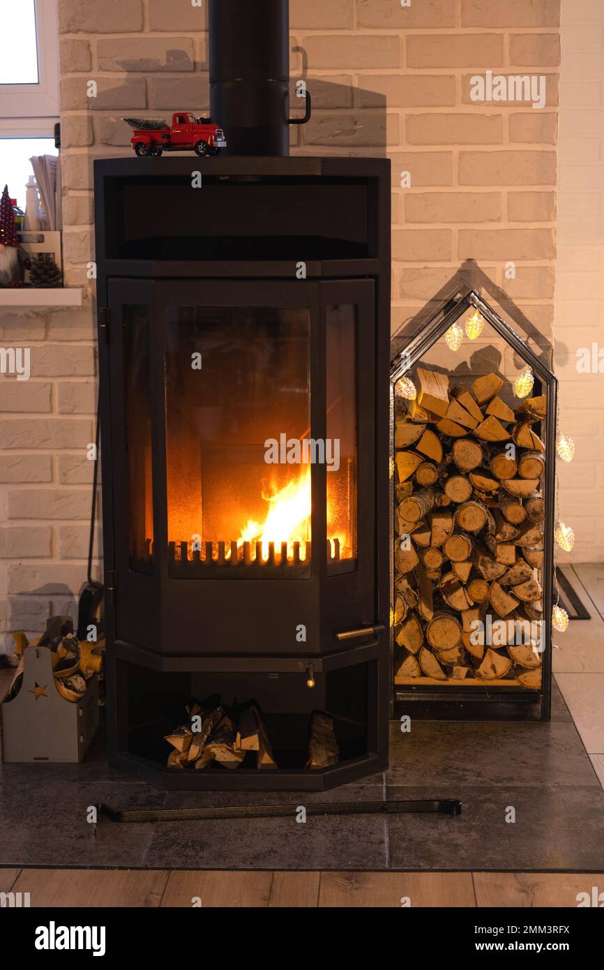 Black metal stove fireplace with wood in a woodpile - the interior of a  private village house. Heating and heating of the house with firewood, the  hea Stock Photo - Alamy