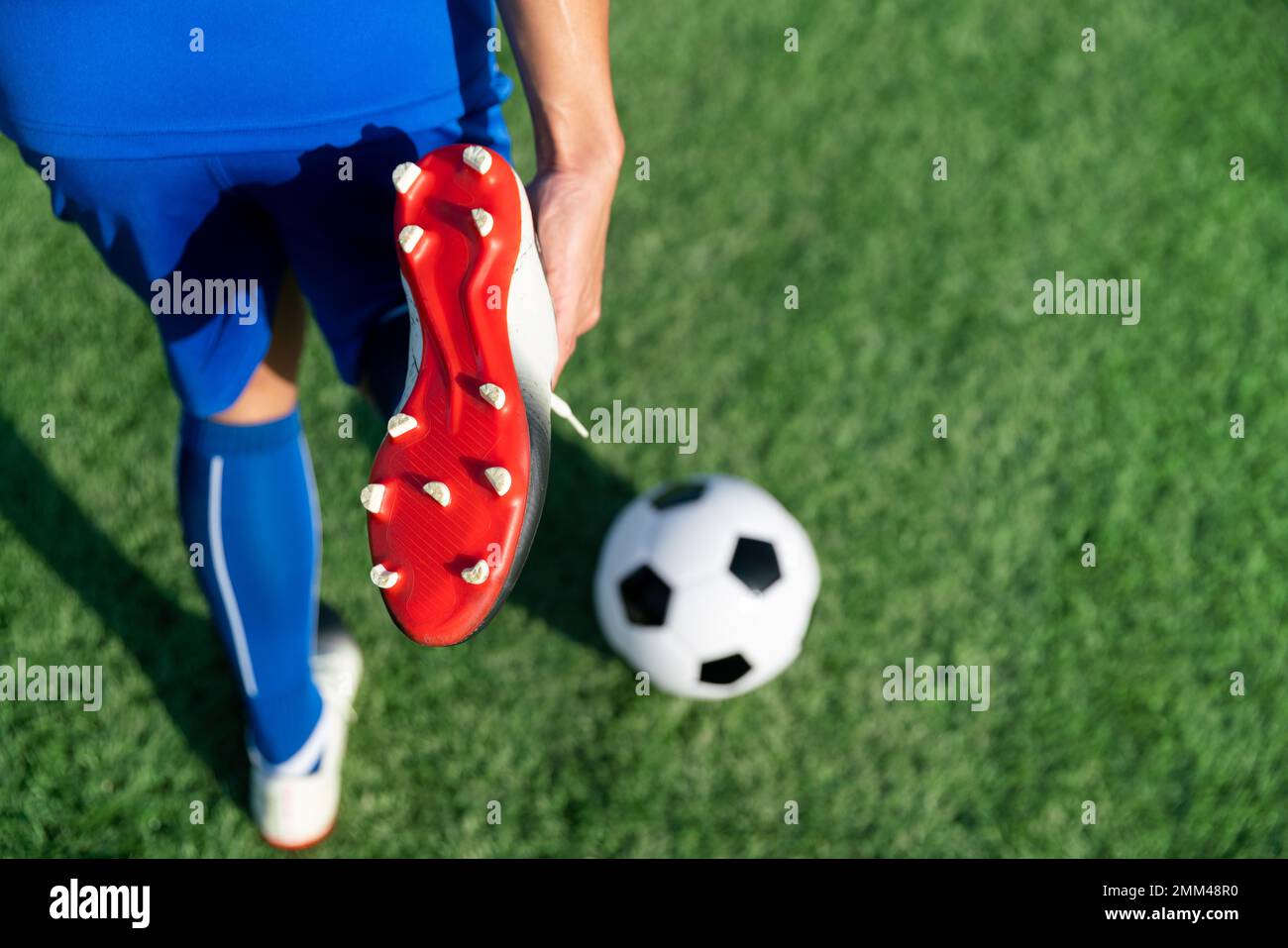football soccer player stretching during warm up before kick ball in