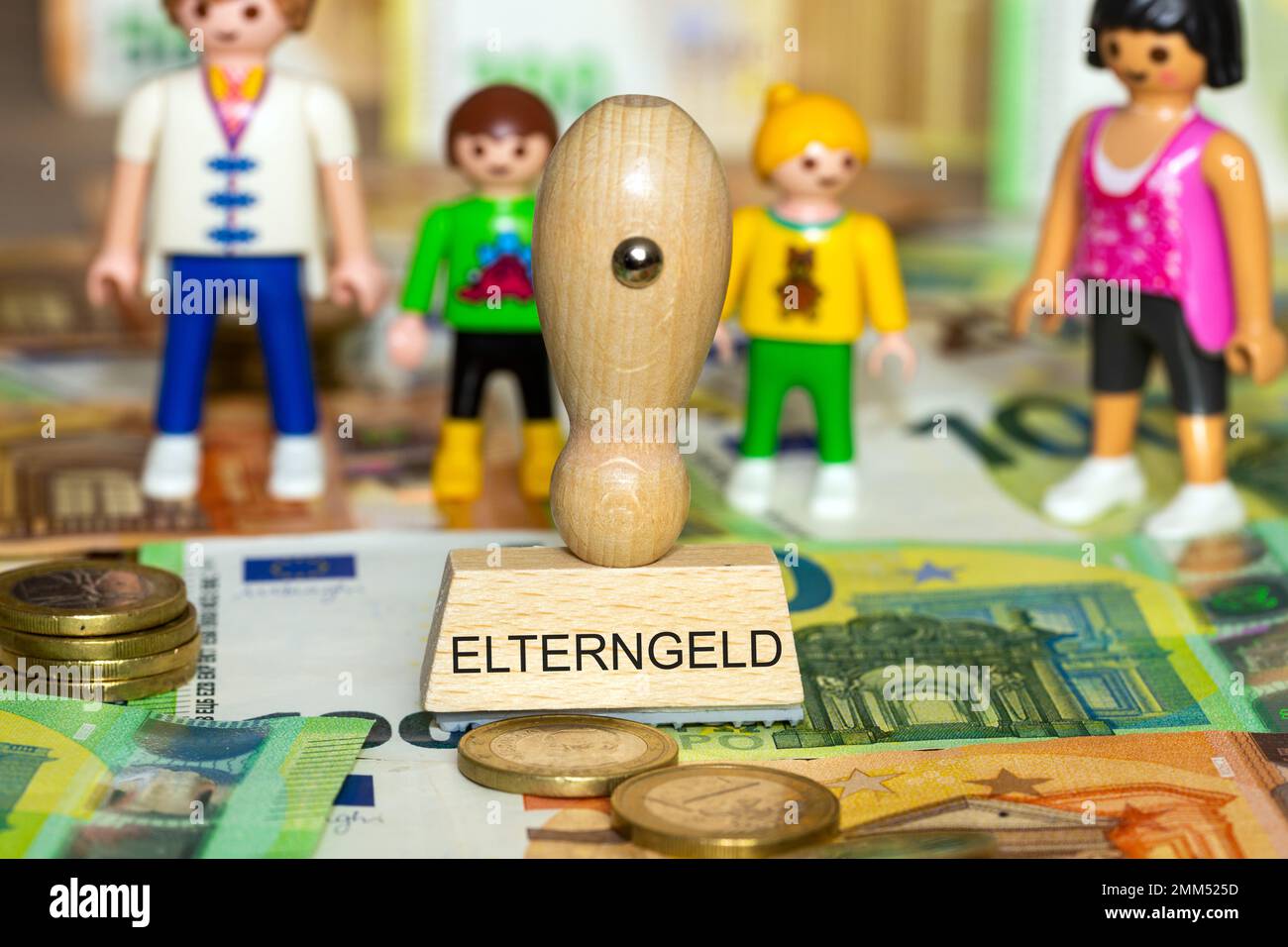 Symbol image of parental allowance: Euro banknotes, game pieces and a stamp with the word Elterngeld (parental allowance) on it Stock Photo