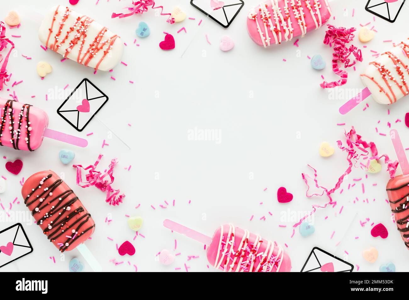 Flatlay collage of Valentine cakesicles and assorted decorations in a border. Stock Photo