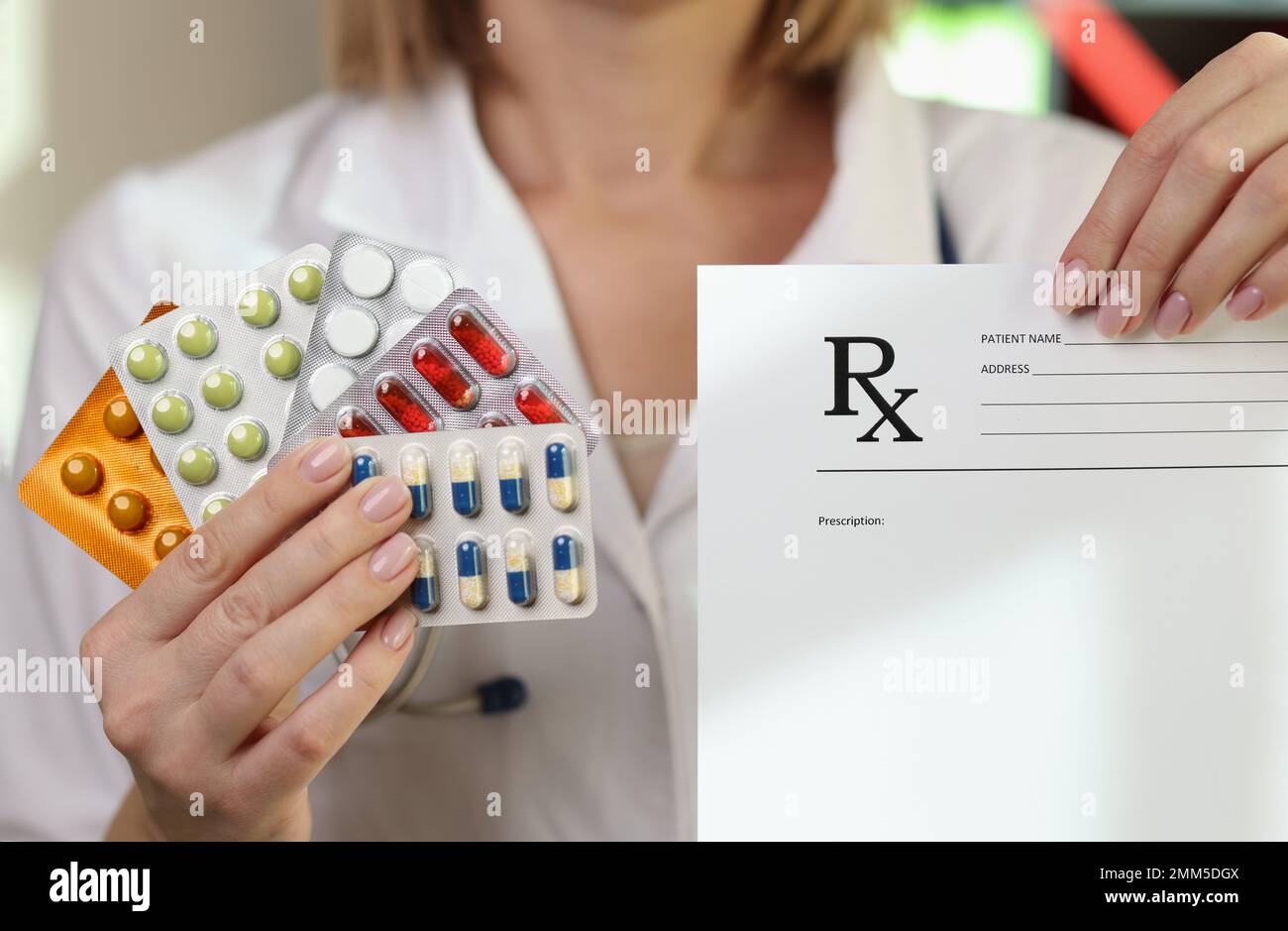 Female doctor shows different medical pills and prescription paper. Stock Photo