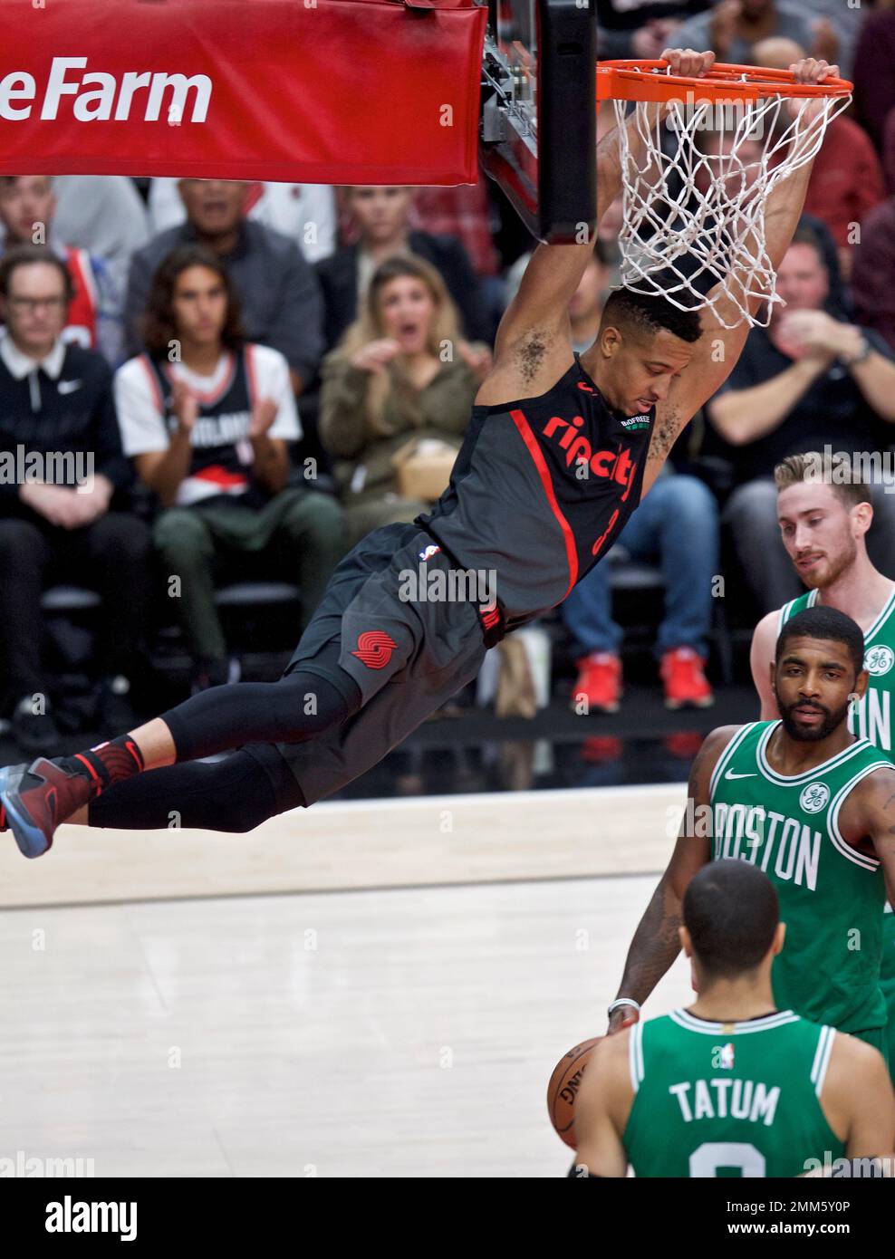 Portland Trail Blazers guard CJ McCollum, left, dunks over Boston