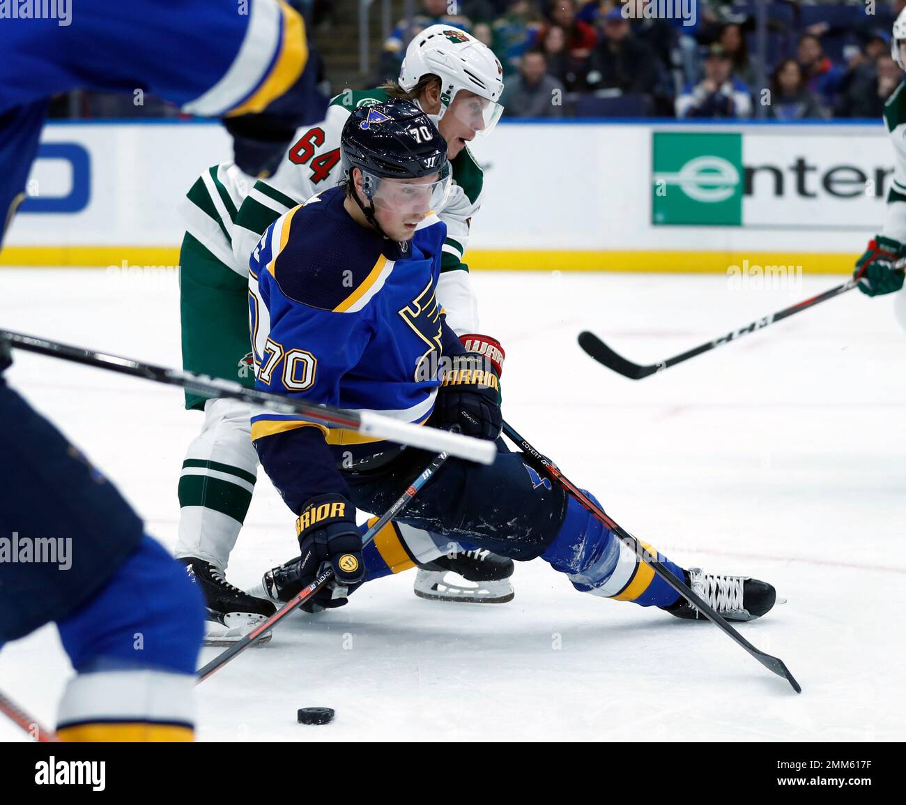 St. Louis Blues' Oskar Sundqvist (70), of Sweden, slips as he brings the  puck downice with Minnesota Wild's Mikael Granlund (64), of Finland, during  the second period of an NHL hockey game