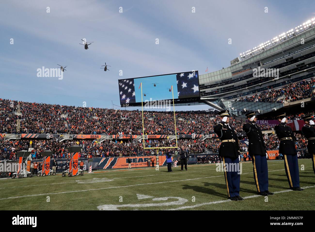 Military personnel salute during pregame ceremonies before an NFL