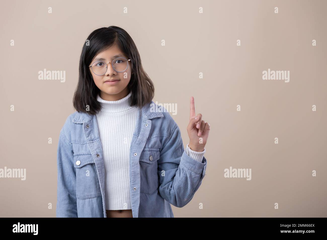 Mexican young woman wearing glasses, pointing up Stock Photo Alamy