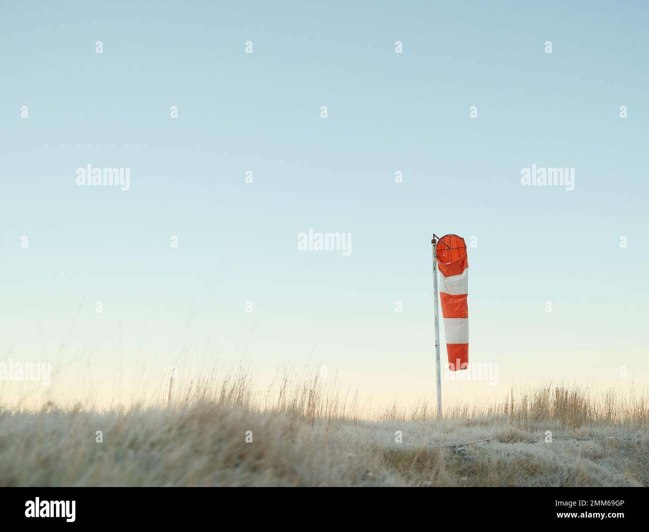 Windsock placed on field against cloudless sky Stock Photo