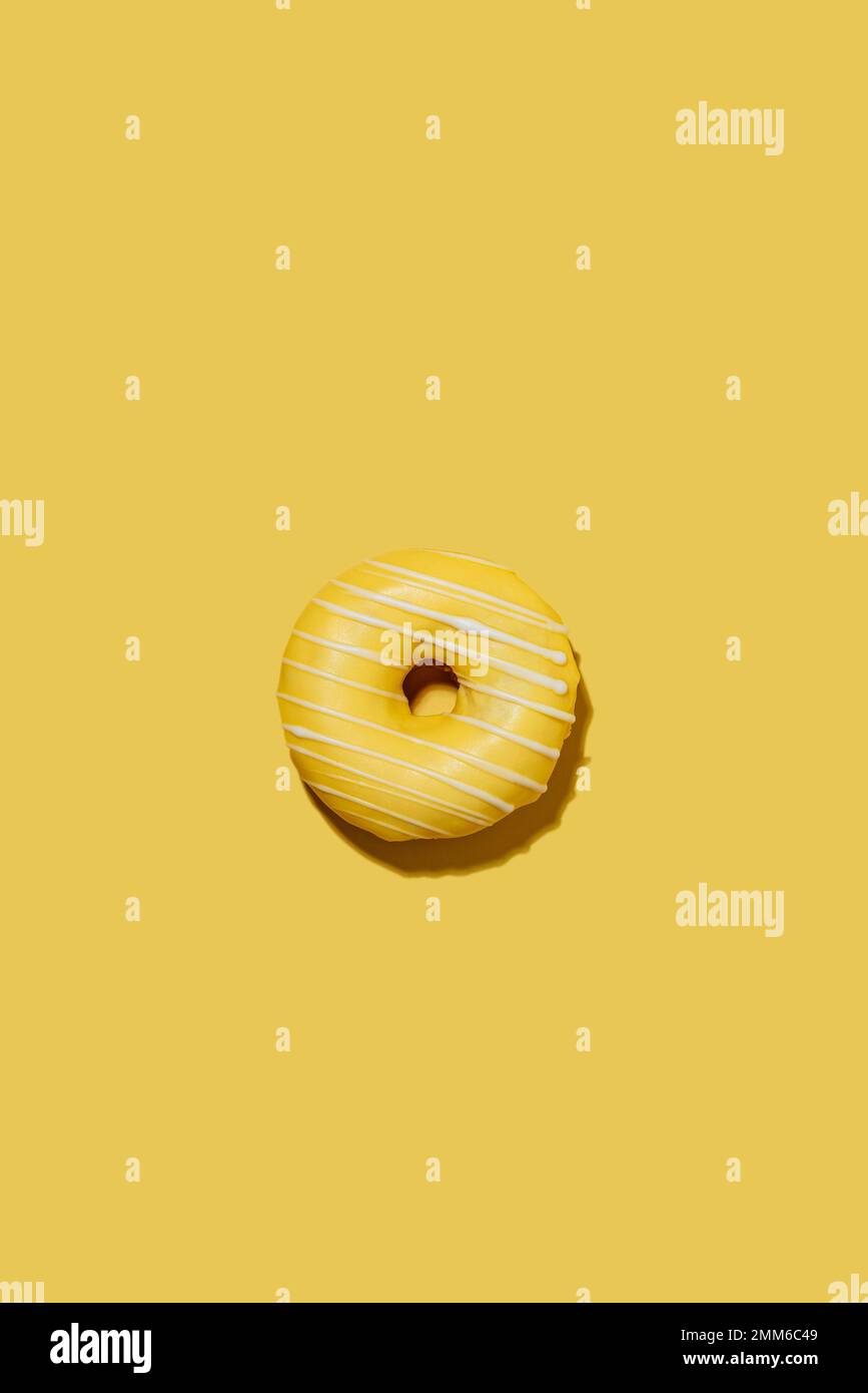 lemon doughnut in yellow glaze on a yellow background. pattern. Stock Photo
