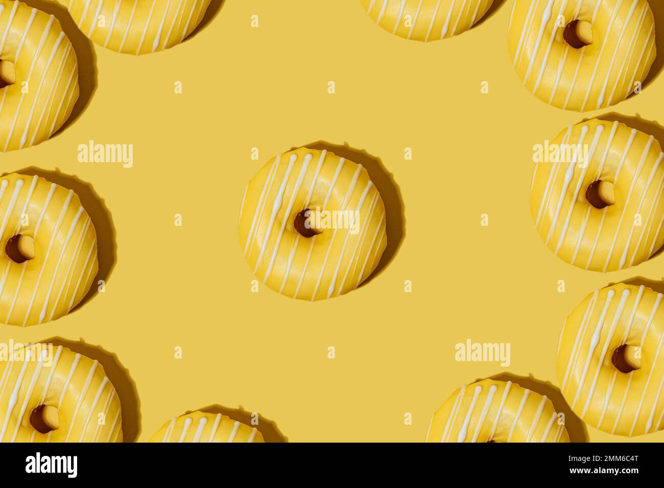 lemon doughnut in yellow glaze on a yellow background. pattern. Stock Photo