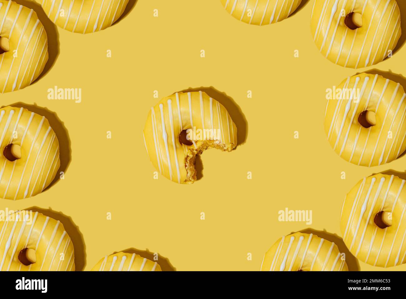 lemon doughnut in yellow glaze on a yellow background. pattern. Stock Photo