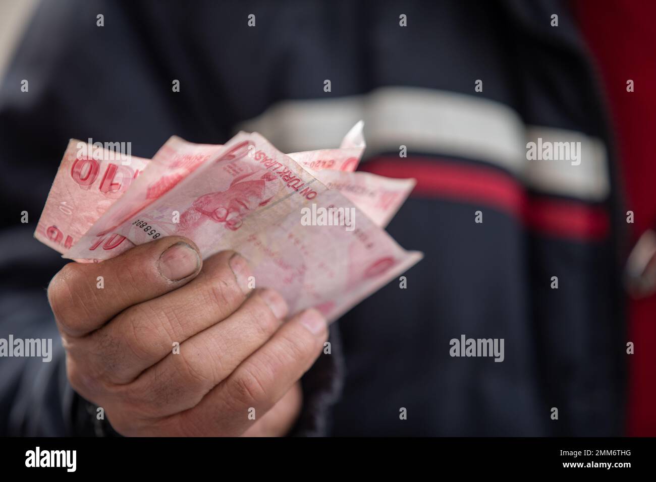 Ankara, Turkey. 29th Jan, 2023. A seller is holding 10 Turkish lira banknotes at a flea market. The flea market, which is set up during the weekends in Ankara Ulus Square, has been visited by more people in recent months due to the high inflation experienced in Turkey. The 64% inflation rate announced by the Turkish Statistical Institute (TUIK) is thought to be higher by many independent economical associations. (Credit Image: © Tunahan Turhan/SOPA Images via ZUMA Press Wire) EDITORIAL USAGE ONLY! Not for Commercial USAGE! Stock Photo