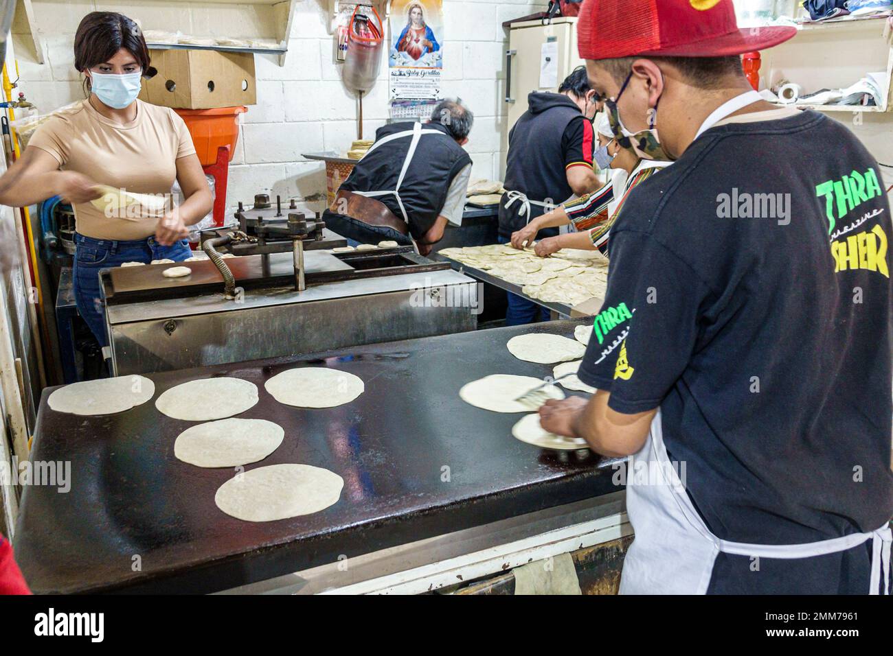 Mexico City,Mercado Medellin,preparing teamwork,grilling tortillas,man men male,woman women lady female,adult adults,resident residents,inside interio Stock Photo