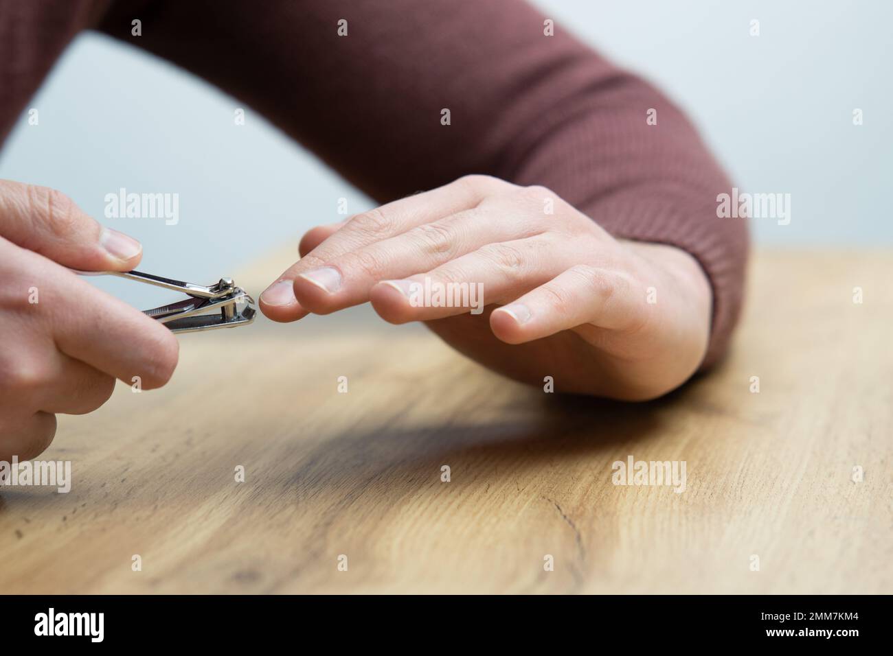 Close up of male hands cutting fingernails. Young handsome man clipping his finger nails Stock Photo