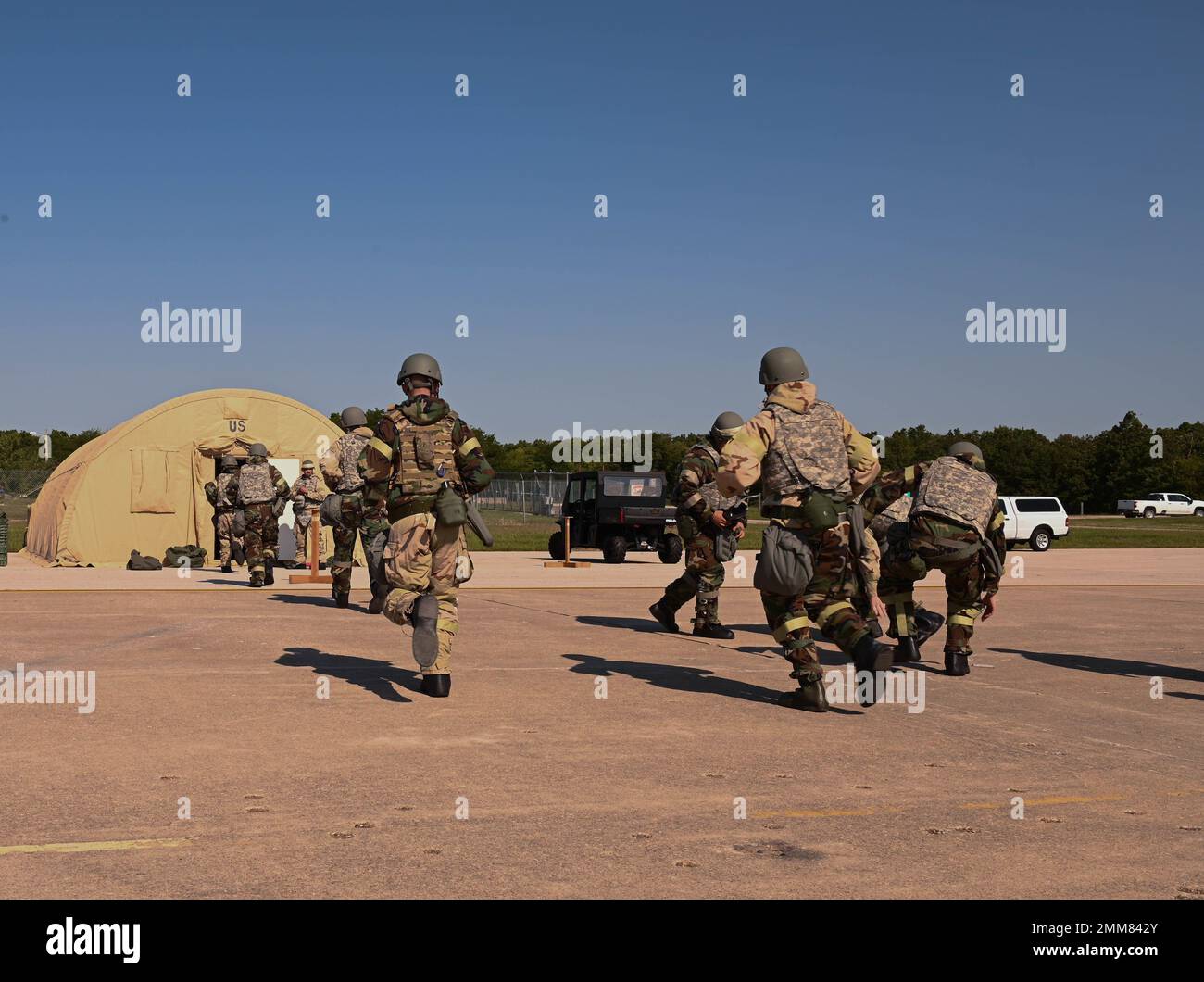 U.S. Air Force Airmen rush to shelter during a CBRN exercise at Whiteman Air Force Base, Missouri, September 15, 2022. Training such as this ensures Airmen are resilient, equipped and combat-ready. Stock Photo