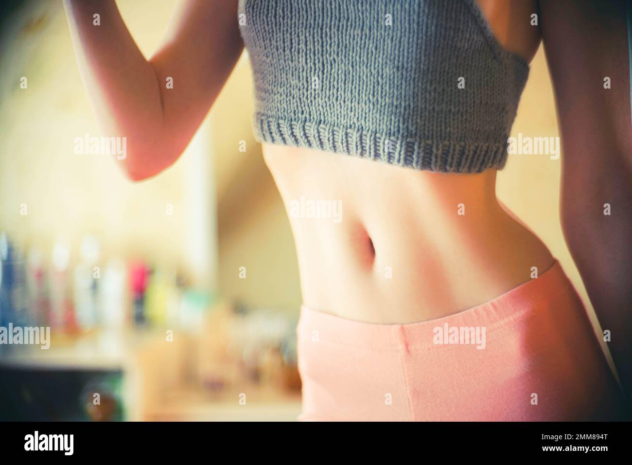 Cropped shot of a young slender woman with toned stomach with abs
