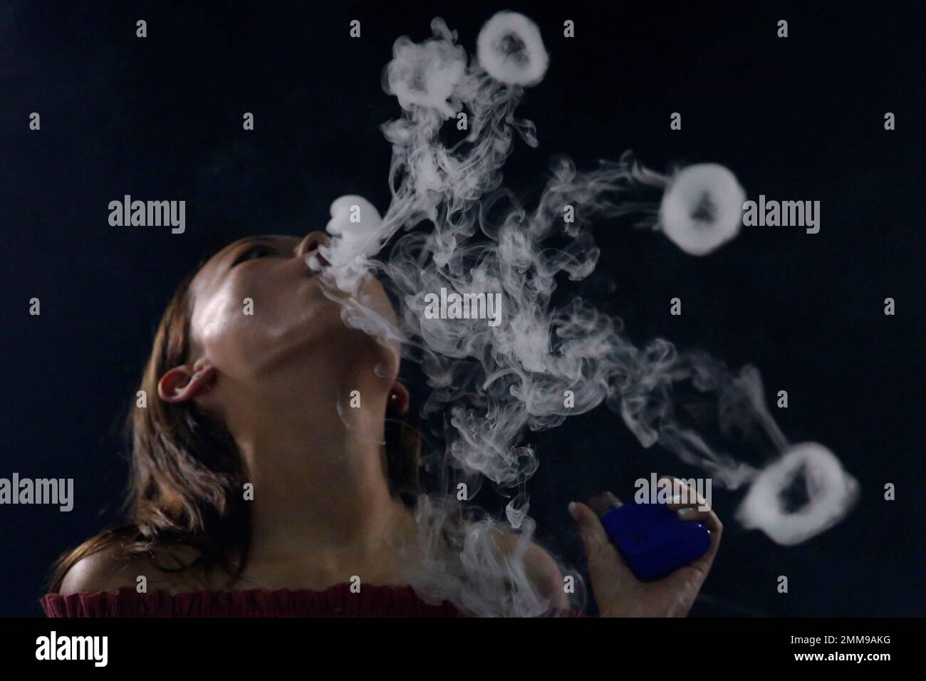 In this Oct. 13, 2018, photo, Jamie Tsang, 20, demonstrates smoking e- cigarette In Hong Kong. Hong Kong's leader says the semi-autonomous Chinese  territory plans to ban e-cigarettes and other new smoking products