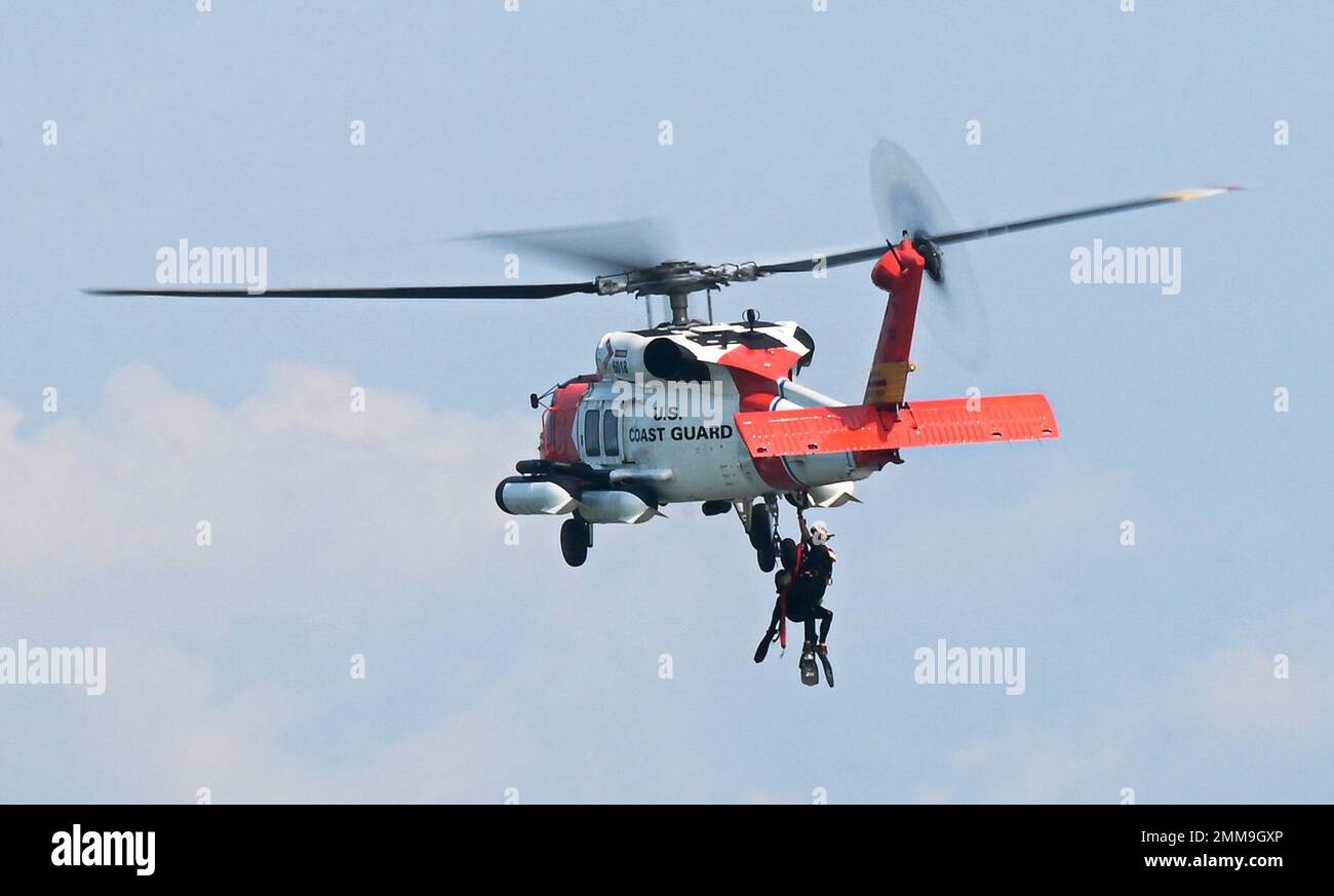 U.S. Coast Guard helicopter aircrew is pulled onto a Sikorsky MH-60T Jayhawk at Joint Base Langley-Eustis, Virginia, Sept. 15, 2022. The HH-60J Jayhawk is a medium-range recovery helicopter used to perform search and rescue, law enforcement, military readiness and marine environmental protection missions. Stock Photo