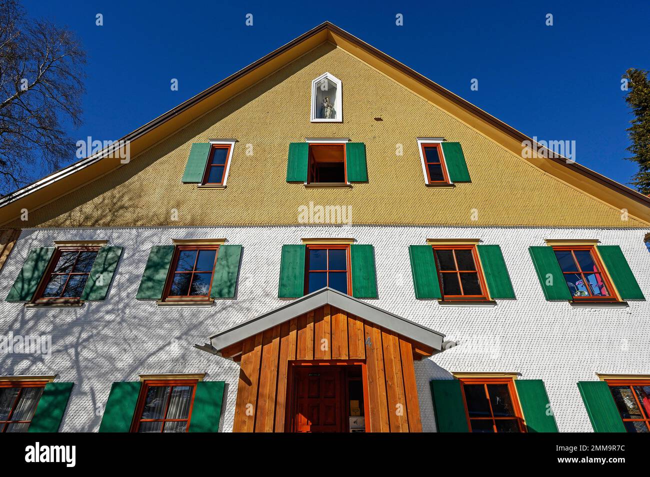 Facade with wooden shingles and figure of the Virgin Mary, Rechtis, Allgaeu, Bavaria, Germany Stock Photo