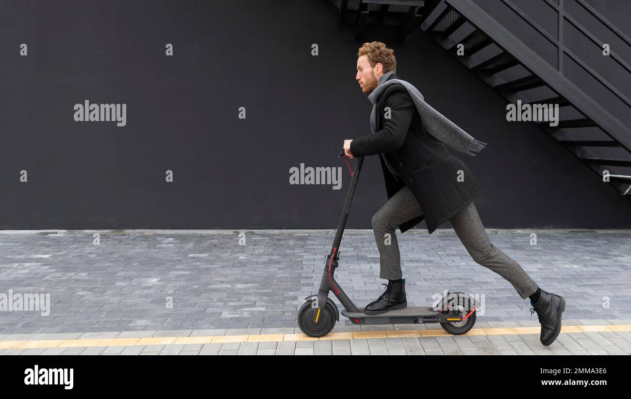 handsome male riding electric scooter. Beautiful photo Stock Photo