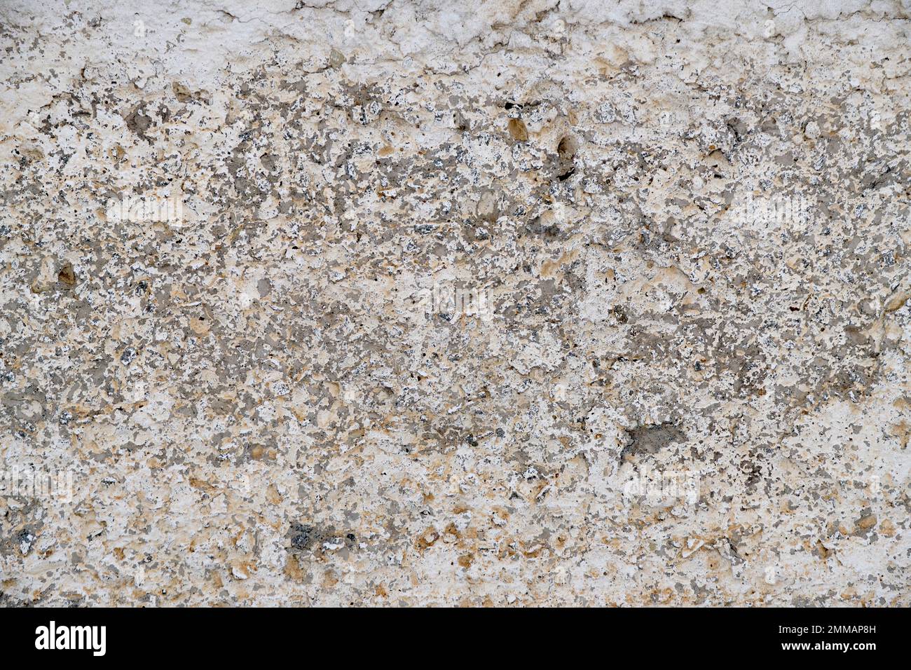 Old, gray concrete wall with peeling white paint Stock Photo