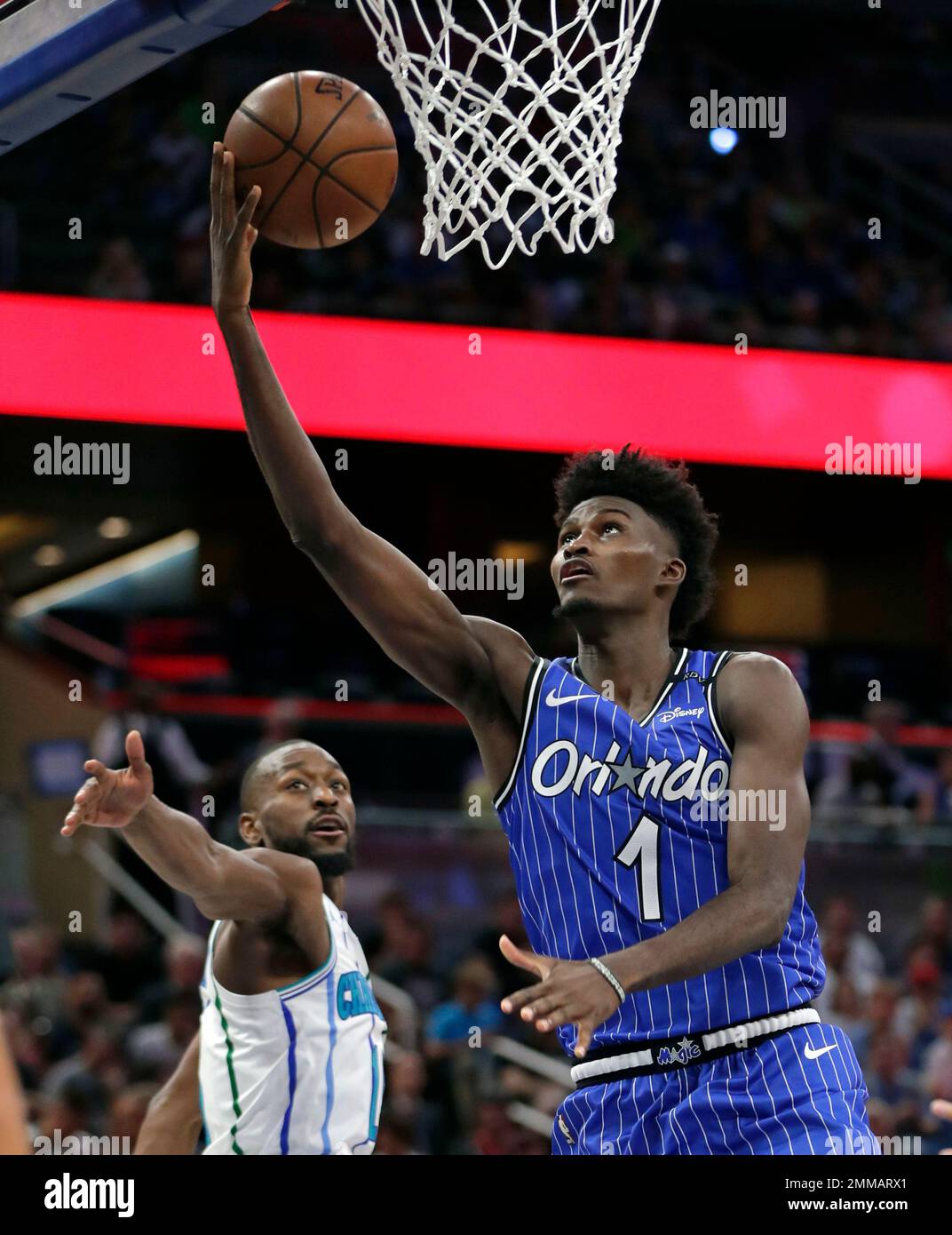 Orlando Magic s Jonathan Isaac 1 goes past Charlotte Hornets Kemba Walker left for a shot during the first half of an NBA basketball game Friday Oct. 19 2018 in Orlando Fla. AP