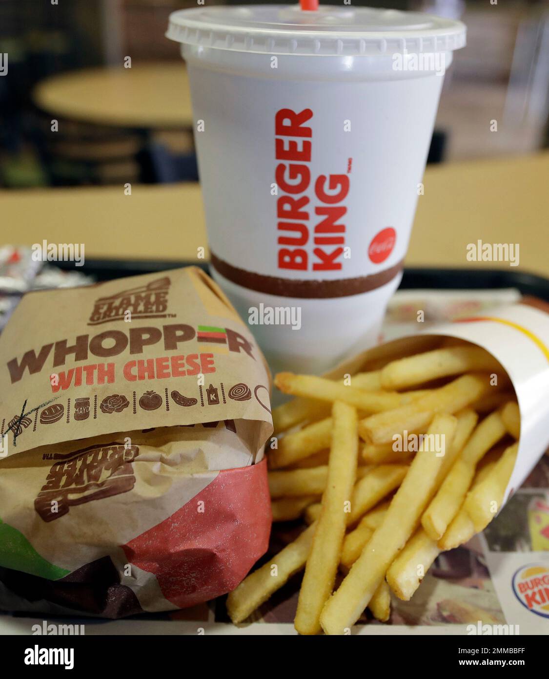 A bacon Whopper with cheese meal sits on a table at a Burger King ...