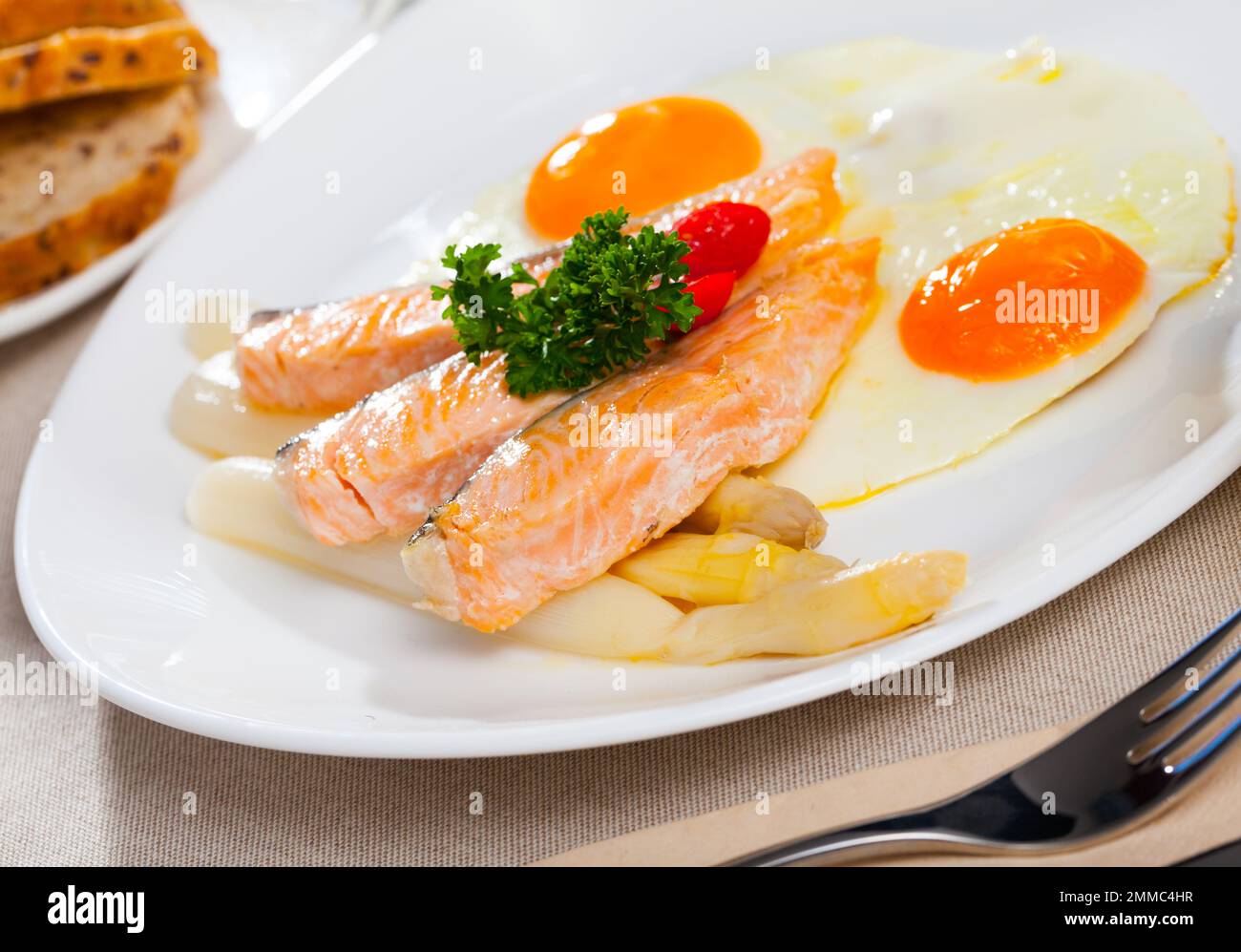 Fried salmon with scrambled eggs and asparagus Stock Photo