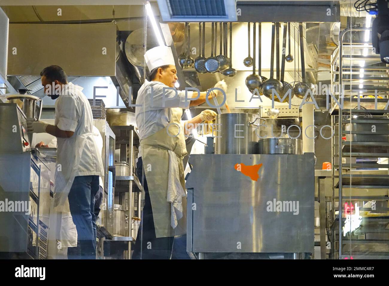 Group of chefs working in a modern kitchen of the restaurant. Milan, Italy - January 2023 Stock Photo