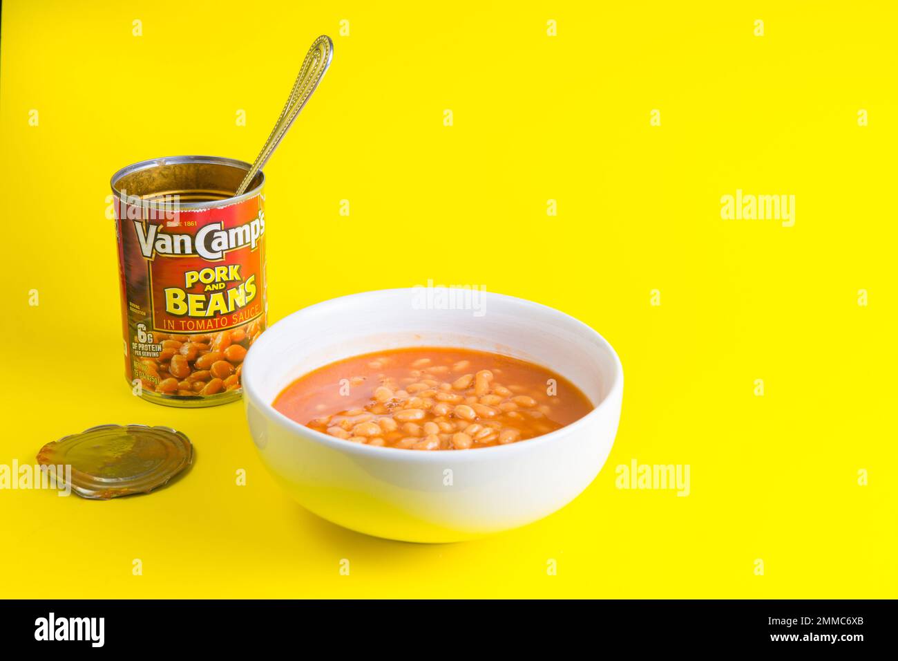 tin of Van Camps Pork and Beans Baked Beans stand out  on a yellow background in a white bowl Stock Photo