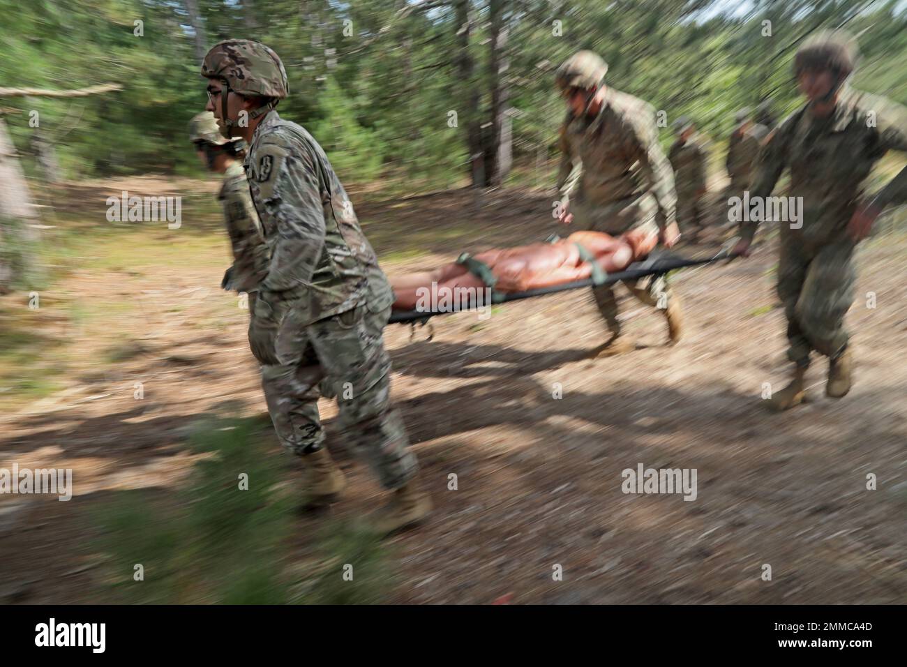 U.S. Army Reserve Spc. William Barrett, front left, assigned to the 452nd Combat Support Hospital, 807th Medical Command (Deployment Support) based in Milwaukee, Wis. and Spc Ashley Carson, left, Spc. Nicholas Radtke and Sgt. Matthew Breitrick run to an obstacle while carrying a 'casualty' on a collapsible litter during a litter obstacle course on Fort McCoy, Wis., Sept. 16, 2022. Stock Photo