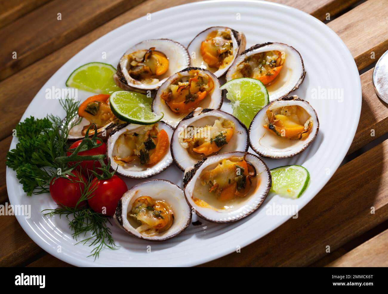 Baked clams with sauce and lime Stock Photo Alamy