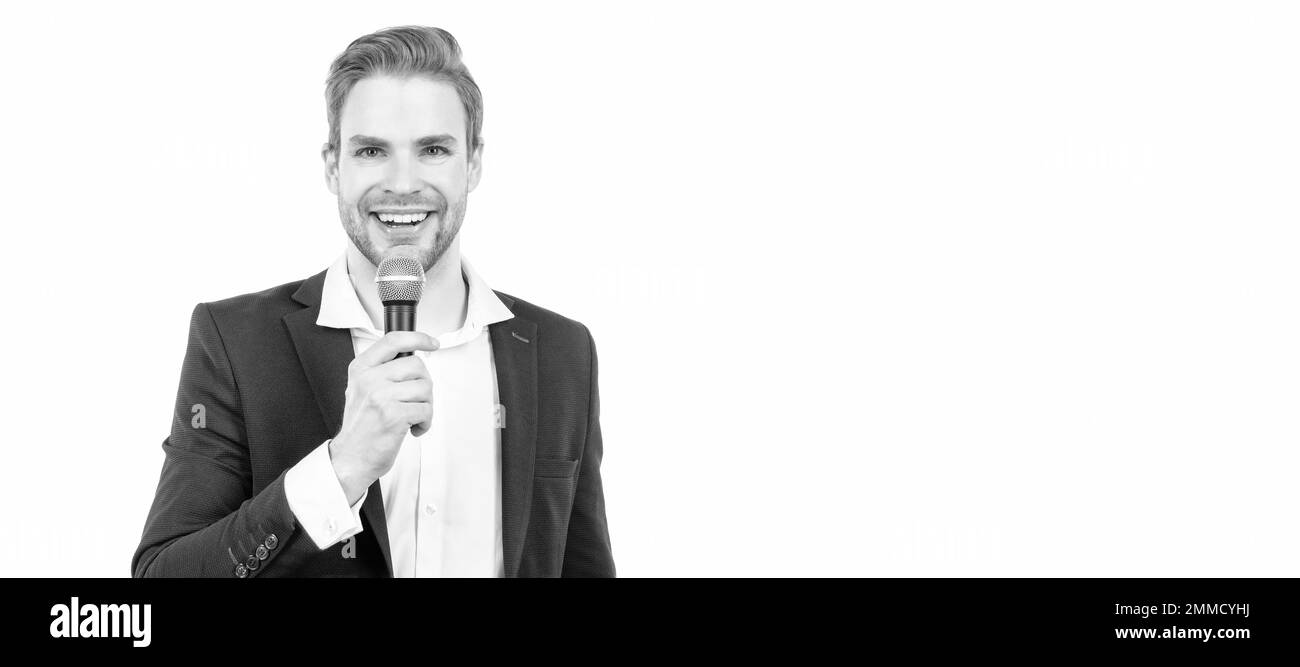 Happy man in business formalwear speak into microphone giving speech isolated on white, conferencier. Man face portrait, banner with copy space. Stock Photo