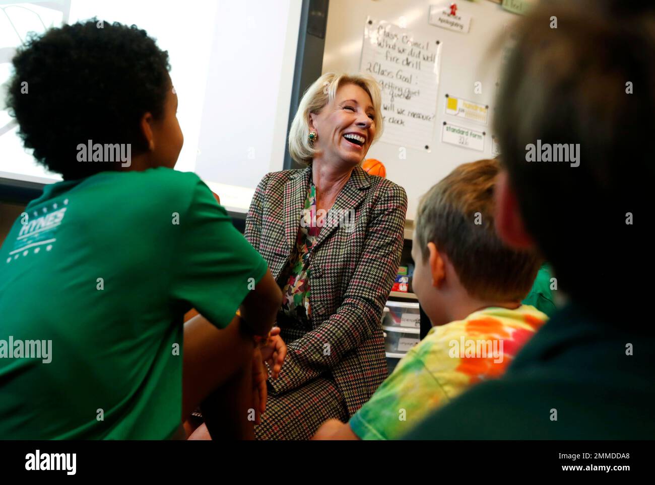 Education Secretary Betsy DeVos laughs as children try to guess her age