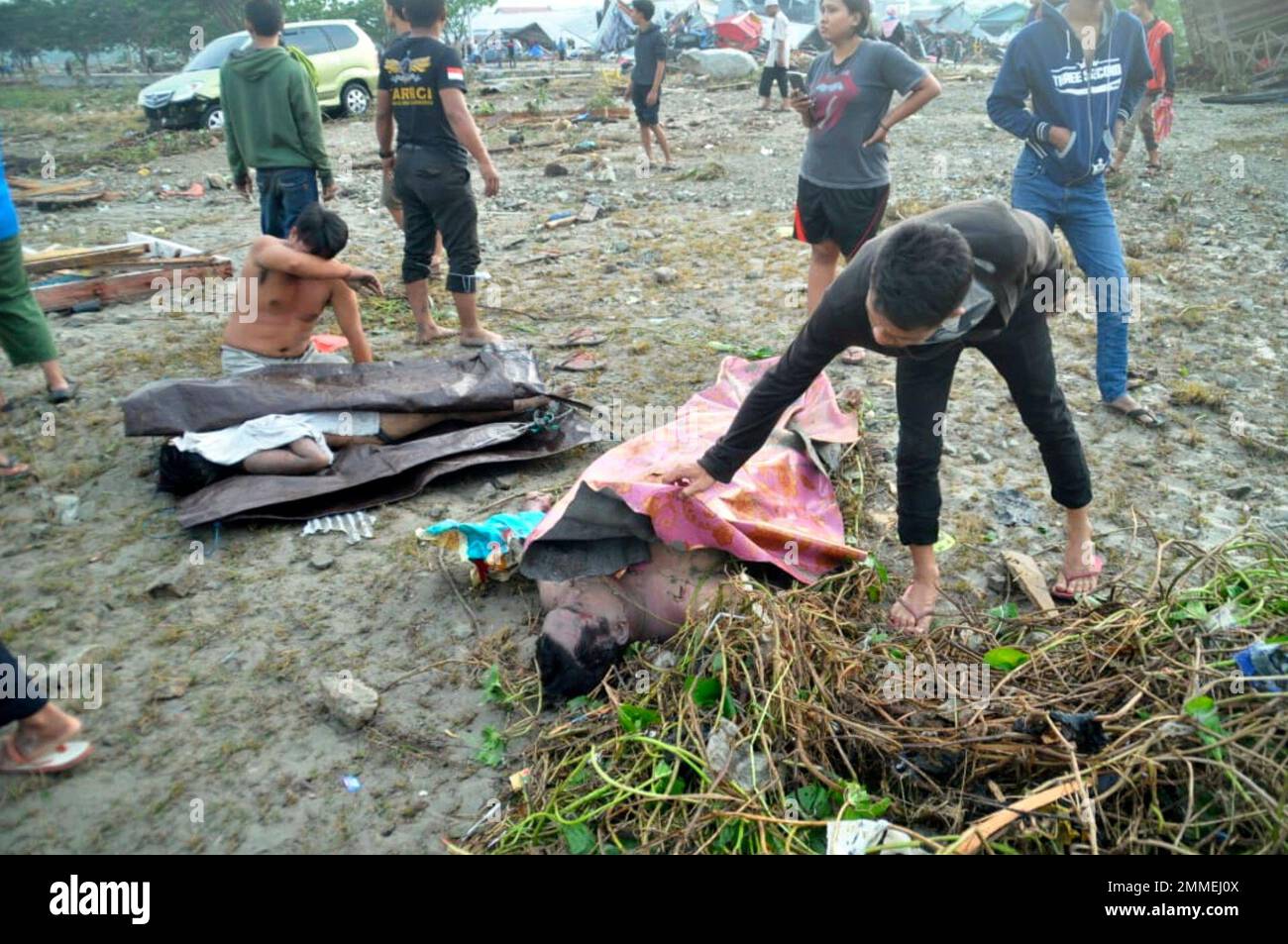 People check the bodies of tsunami victims as they try to find their loved  ones in Palu, Central Sulawesi, Indonesia, Saturday, Sept. 29, 2018. A  tsunami swept away buildings and killed large