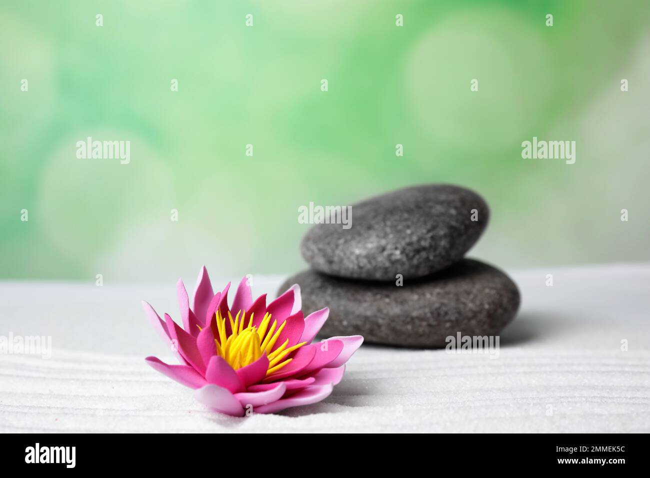 Zen garden. Beautiful lotus flower and stones on white sand Stock Photo