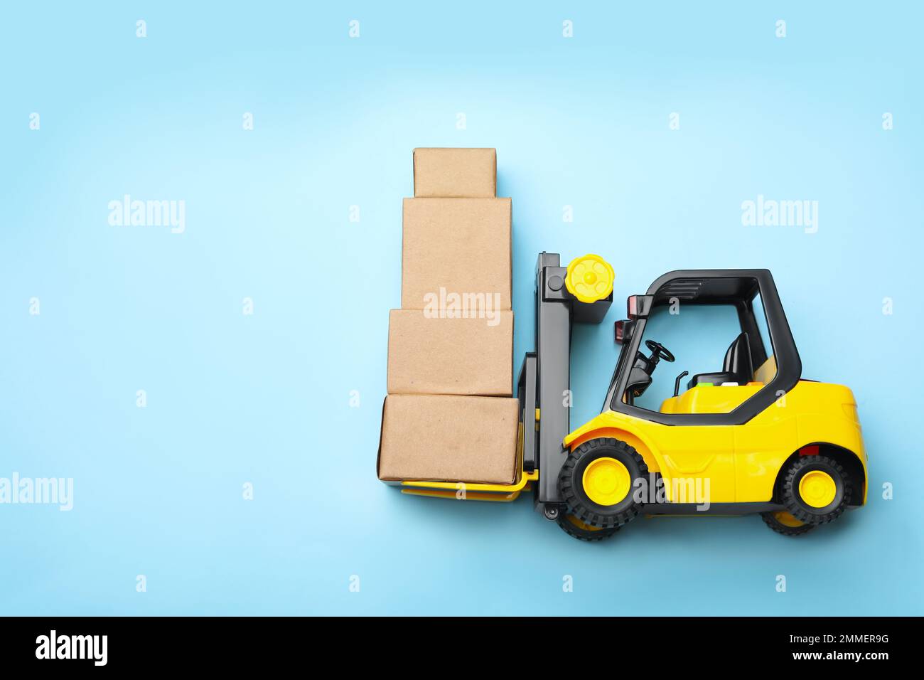 Top view of toy forklift with boxes on blue background, space for text.  Logistics and wholesale concept Stock Photo - Alamy