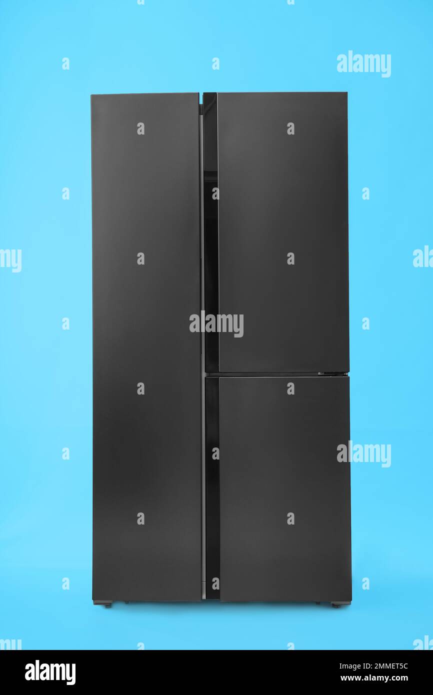 Modern stainless steel refrigerator on blue background Stock Photo Alamy