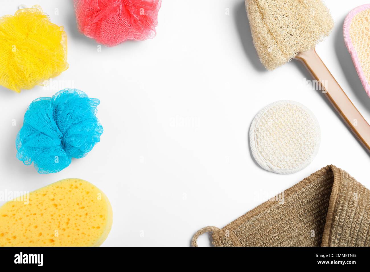 Plastic and natural shower sponges on white background, top view