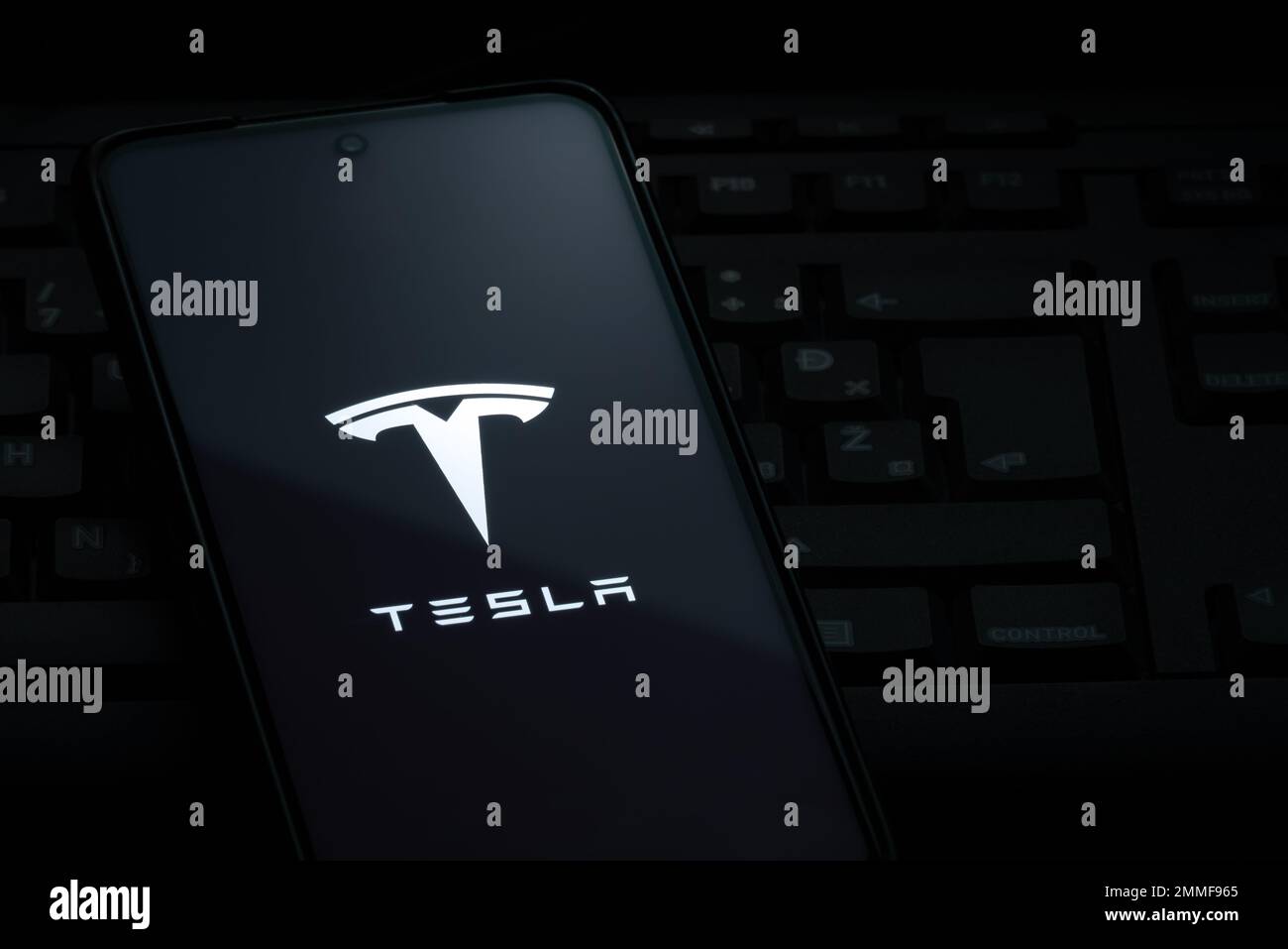 Ljubljana, Slovenia - 21 January 2023: Tesla logo on smartphone screen laying on computer keyboard Stock Photo