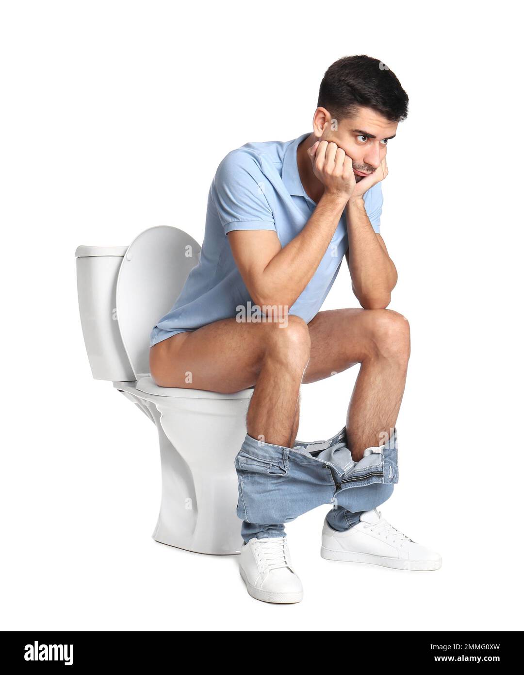 Man sitting on toilet bowl, white background Stock Photo Alamy