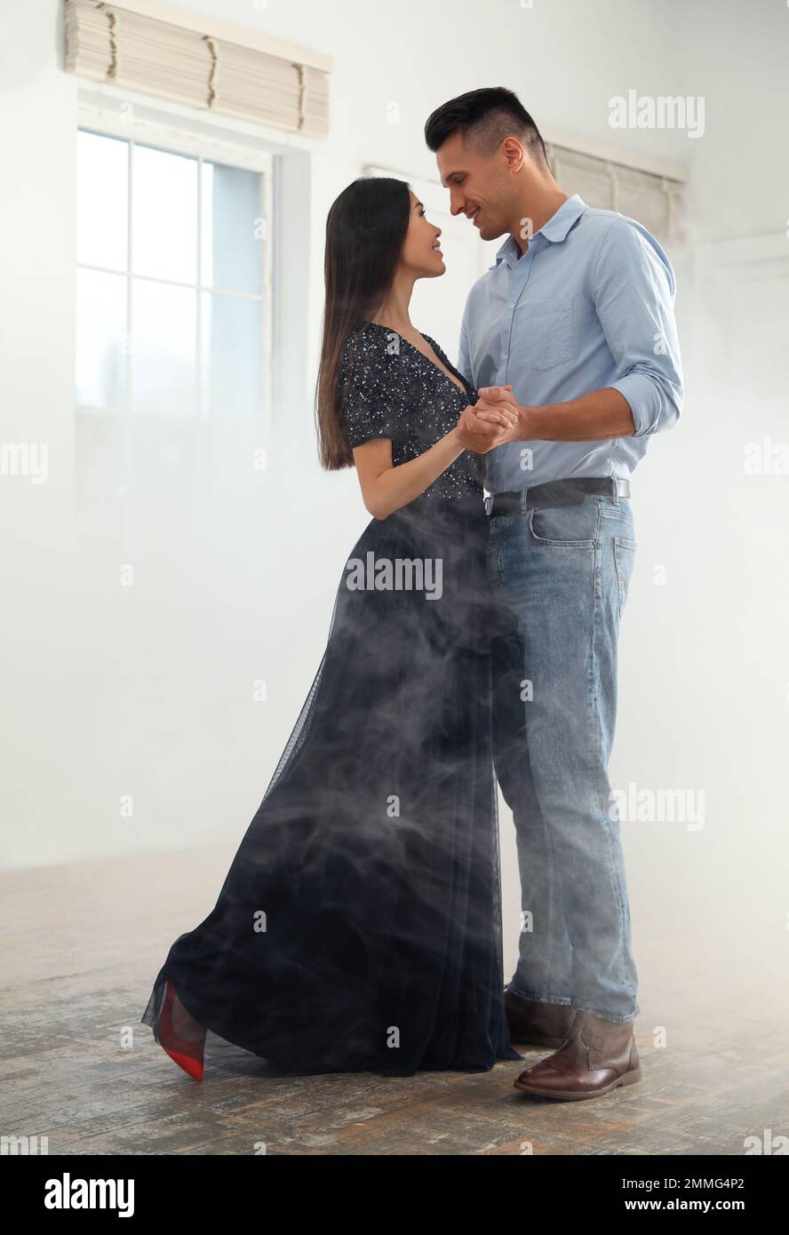 Lovely young couple dancing together in ballroom Stock Photo