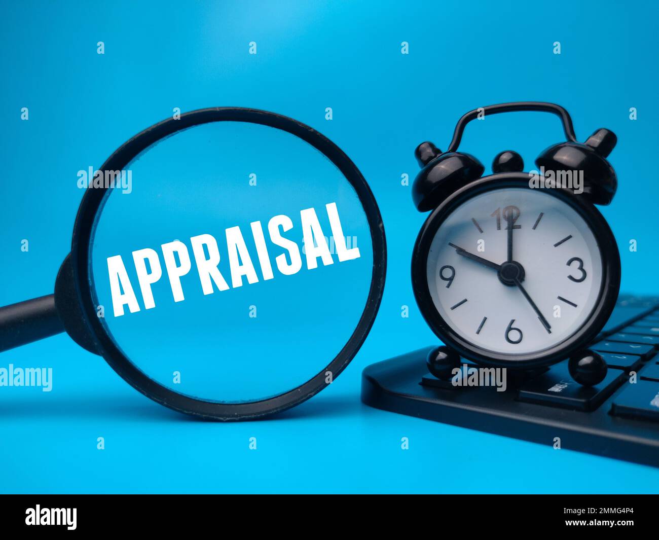 Magnifying glass and alarm clock with the word APPRAISAL. Stock Photo