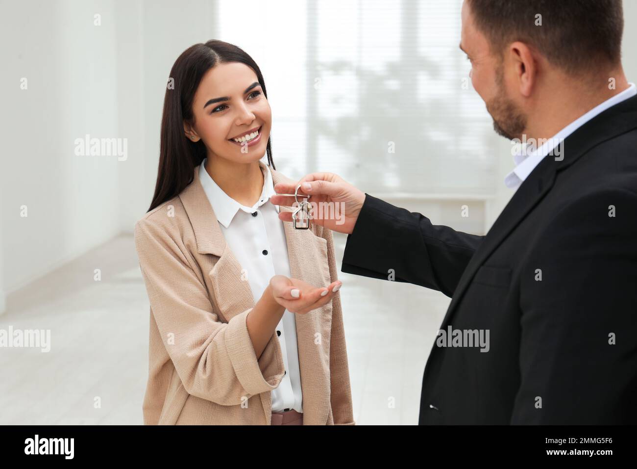 Real estate agent giving key to client in new apartment Stock Photo - Alamy